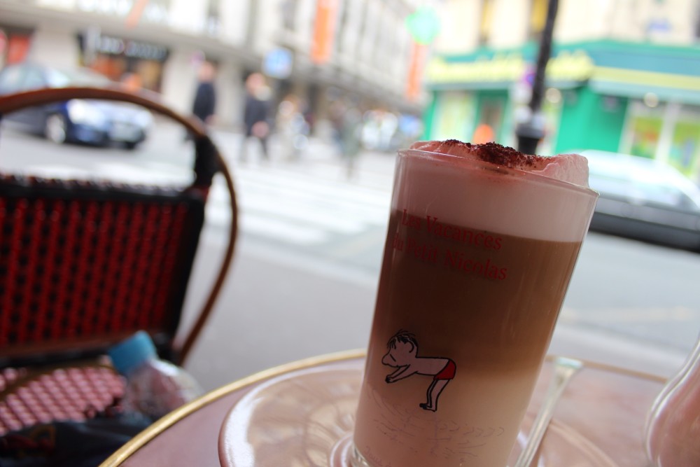 A coffee at a Paris cafe with a view of the street and shops in the background
