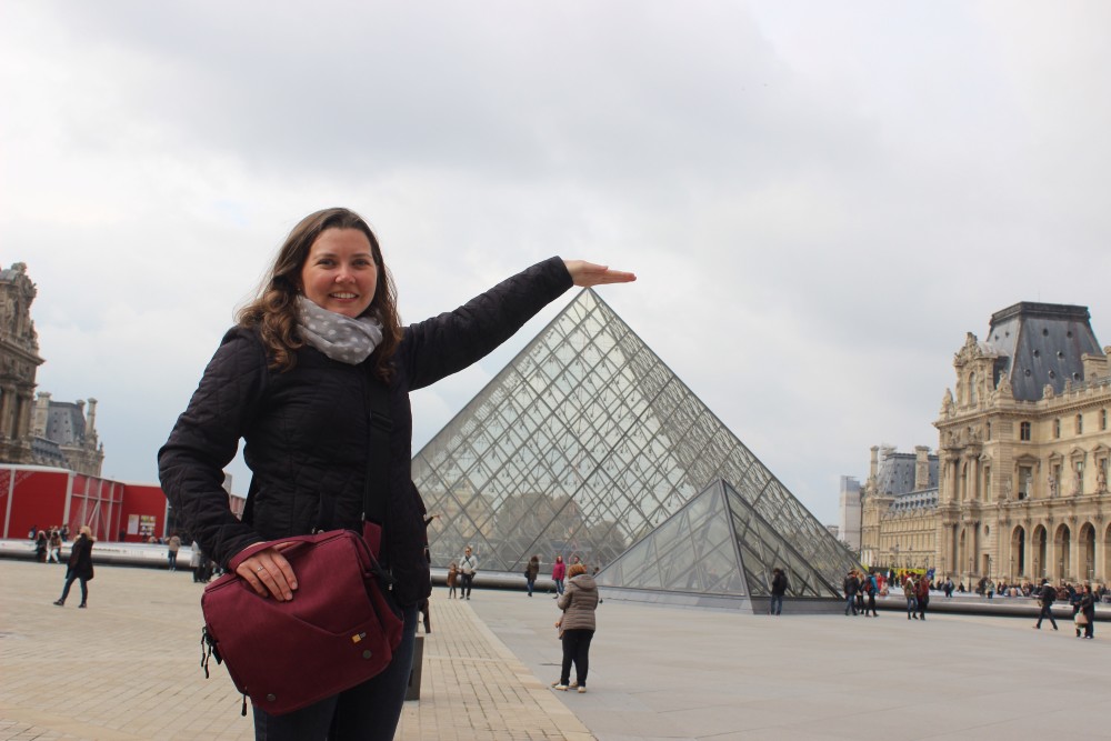 Putting hand over glass pyramid at the Louvre in Paris, France