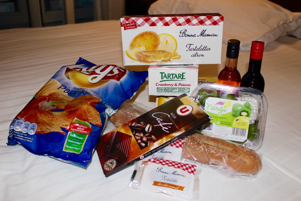 Snacks and wine on a hotel bed in Paris, France