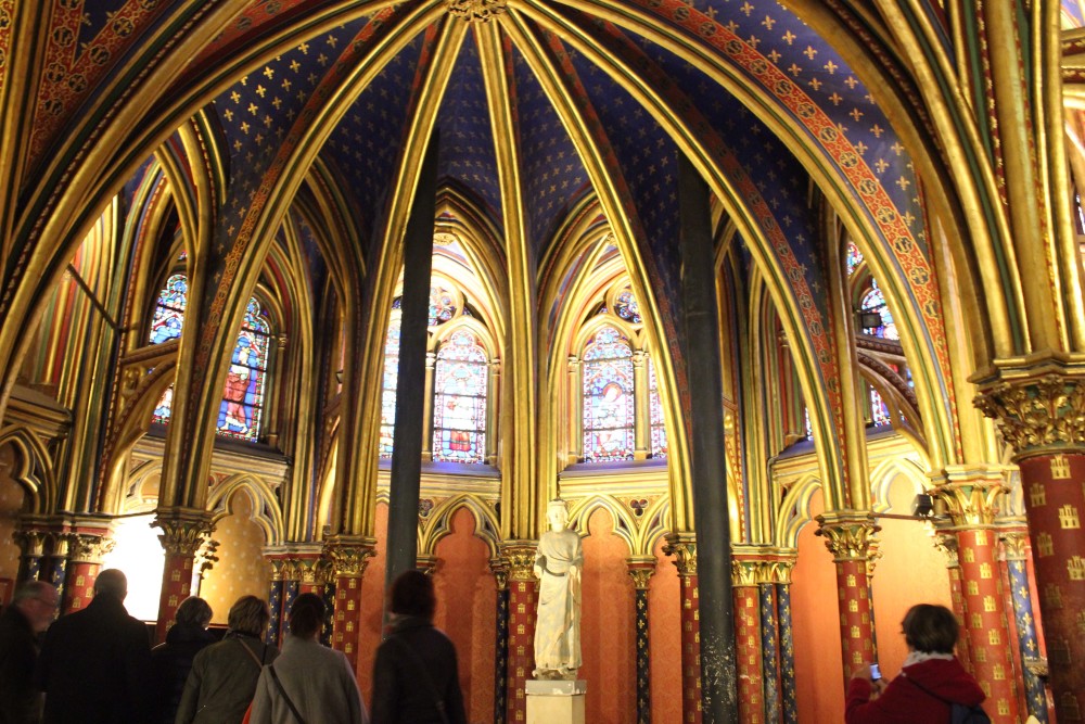 First floor of Saint-Chapelle in Paris, France with gold highlights, blue ceilings, and peach colored walls