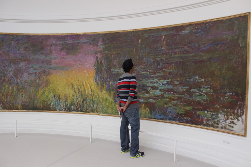 Studying the water lily painting in the Musee de l'Orangerie in a white oval room