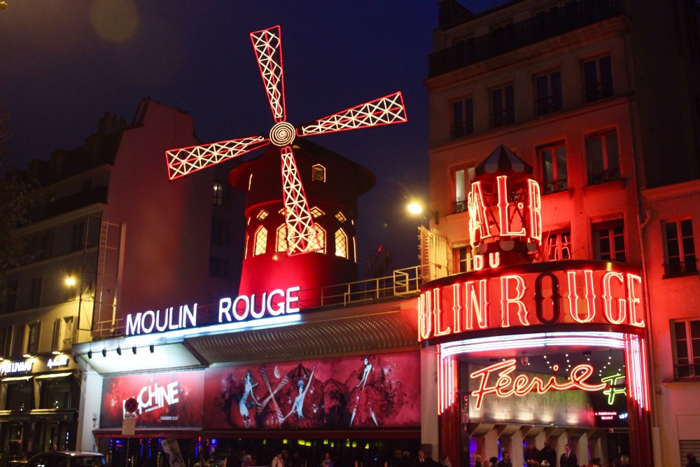 The Moulin Rouge lit up in red at night in Paris, France
