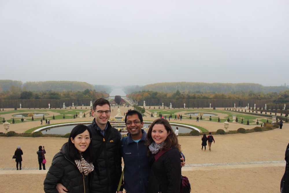 Standing in front of the large fountain and gardens at Versailles