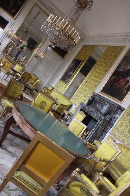 Versailles room with yellow printed wallpaper and yellow chairs 
