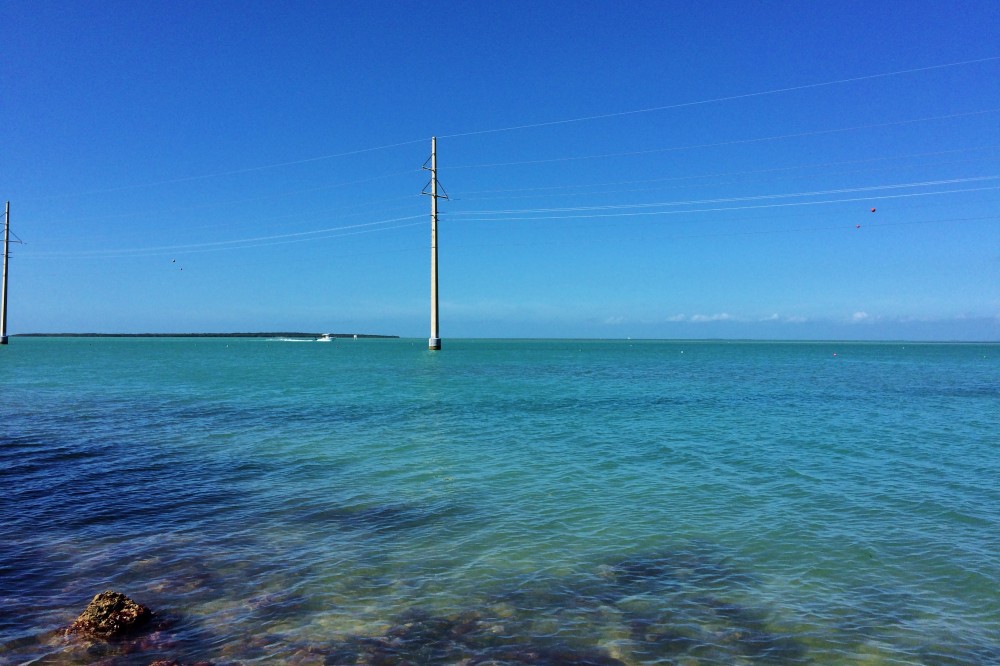 Drive in the Keys, crystal clear water, blue skies, and power line poles in the water