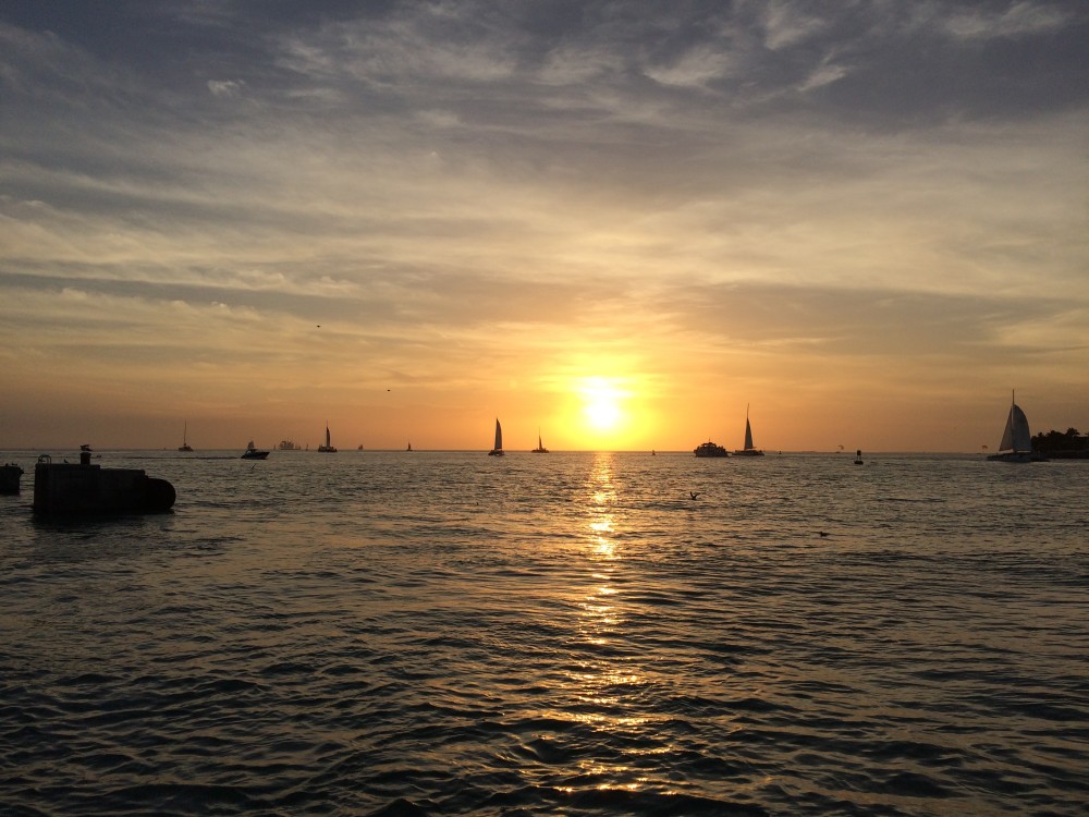 Sunset at key west with a view of the ocean and several sailboats