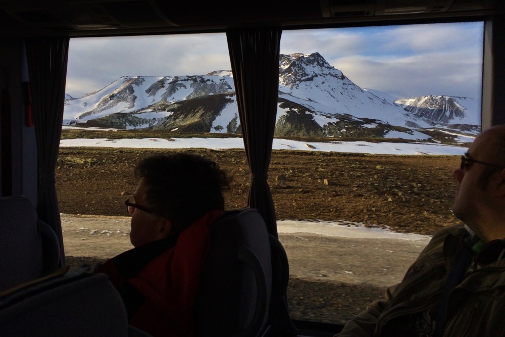 Huge lava rock fields and mountains as seen inside GeoIceland Shuttle Bus during the golden circle tour