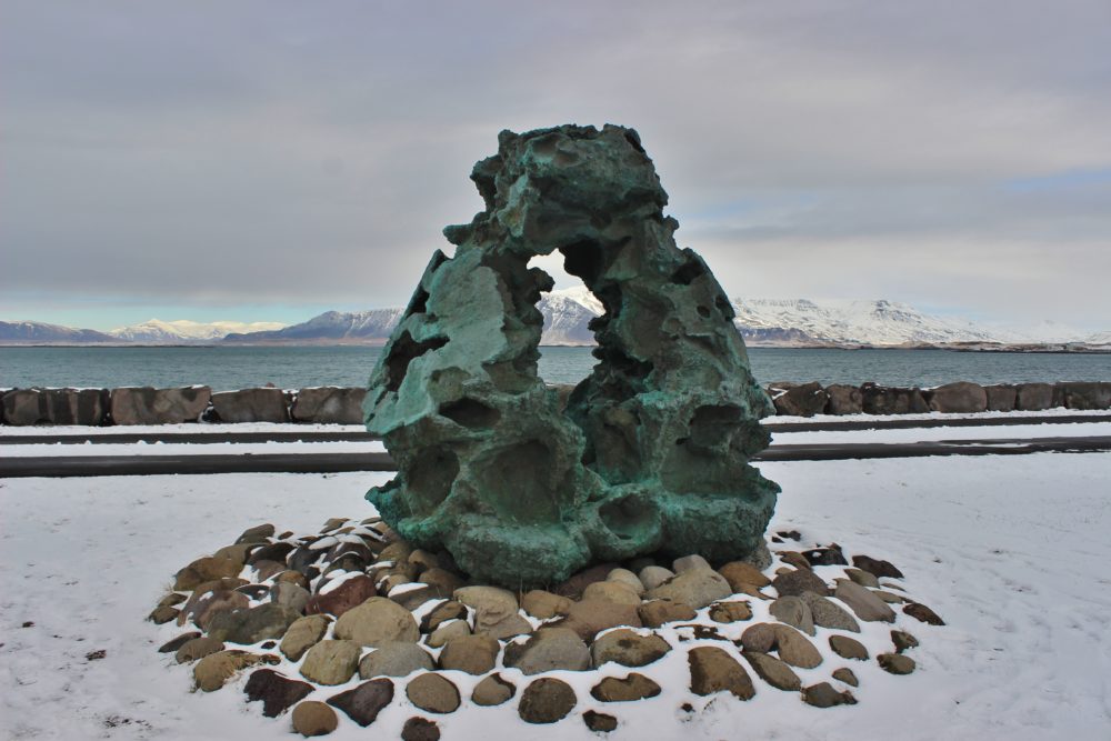 Sculpture on the shore of Reykjavik with snowy mountains in the background