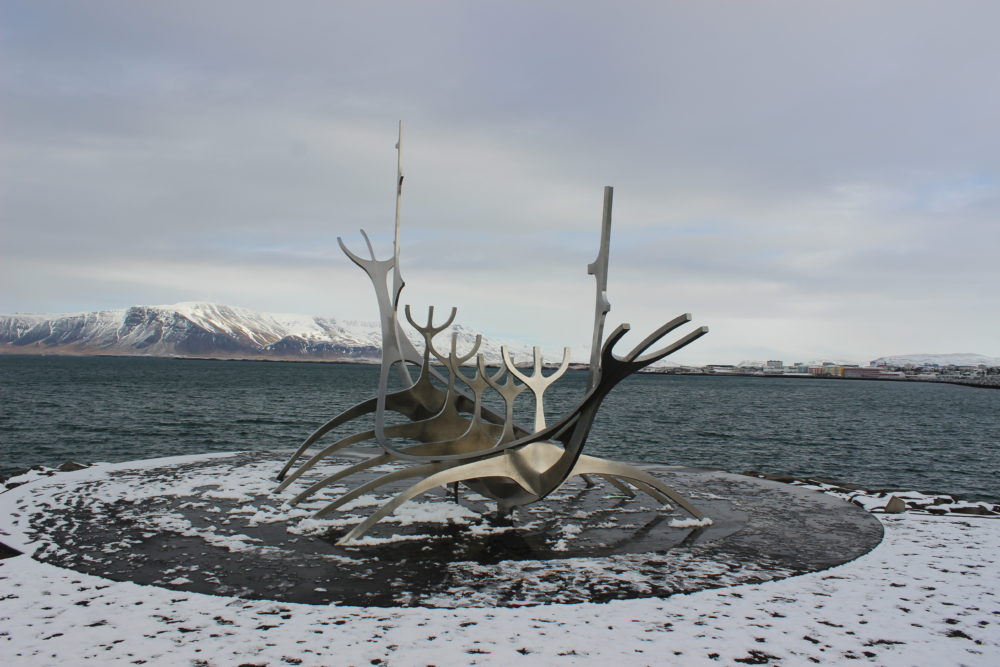 The Sun Voyager with snow in Reykjavik with the bay and mountains in the background