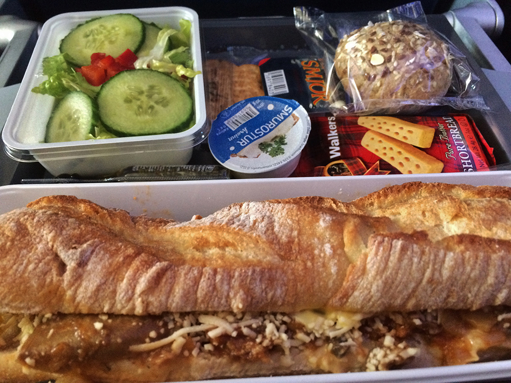 lunch of a roasted veggies and cheese stuffed baguette and a side salad on Delta KEF to JFK